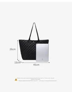 Close-up of quilted black tote bag dimensions with iPad for capacity reference