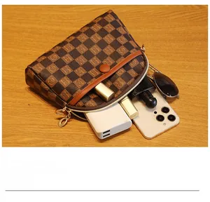 Détail intérieur du sac à motif damier marron montrant sa capacité de rangement pratique