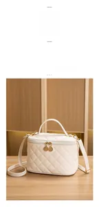 Détail du sac en cuir blanc matelassé avec double fermeture éclair dorée élégante