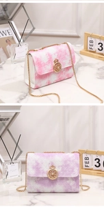 Detail of quilted chain bags with crown buckles in pink and purple tie-dye gradient