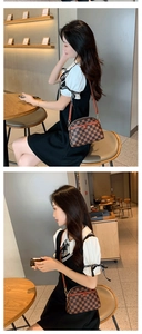 Sac bandoulière coquille à carreaux marron porté par un mannequin dans un café