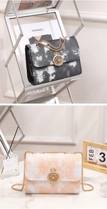 Close-up of marble pattern chain bag with golden crown clasp and metal snake chain