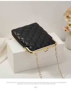 Détail du sac bandoulière matelassé noir avec fermoir métallique doré et fine chaîne