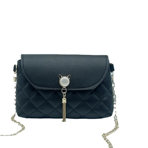 Quilted black chain handbag with elegant pearl cat tassel buckle on a white background