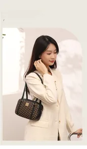 Close-up of brown textured crossbody bag featuring gold buckle and black leather trim