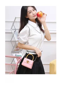 Détail du mini sac rose gaufré croco avec poignée en bambou classique et chaîne dorée