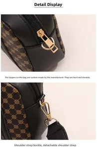 Detail of dark brown crossbody bag with gold zippers and removable fabric strap