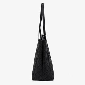 Black quilted tote bag with diamond pattern and long shoulder straps in side view