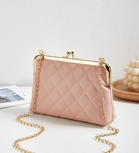 Gros plan d'un sac rose matelassé avec cadre doré vintage et bandoulière en chaîne