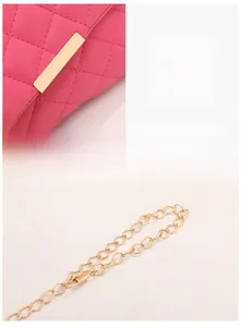 Detail of pink quilted leather crossbody bag with gold metal lock and chain strap