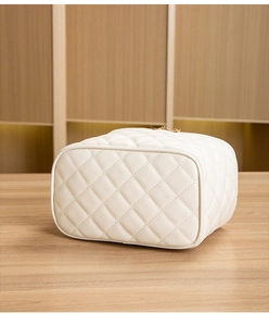Détail de la trousse de maquillage matelassée crème avec fermeture éclair dorée