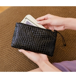 Black crocodile embossed clutch showing interior storage for bills and cards