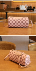 Detail der rosa karierten Zylindertasche mit goldenen Beschlägen und HORHE-Logo
