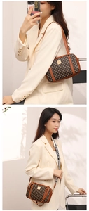 Detail of vintage patterned crossbody bag with wide shoulder strap and leather handles