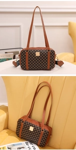 Detail of vintage canvas handbag with leather trim and gold-tone metal plaque hardware