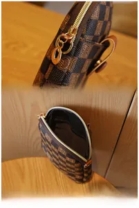 Detail of premium golden metal zipper and internal compartment of checkered crossbody bag