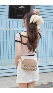 Detail of a khaki crossbody bag with H-pattern jacquard fabric and leather flap