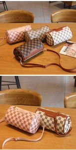 Detailansicht stilvoller gemusterter Zylindertaschen in verschiedenen Farben auf Holz