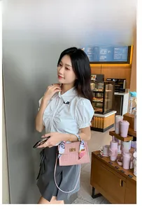 Rosa Handtasche mit Webstruktur und Seidenschal in einer lässigen Alltagsszene