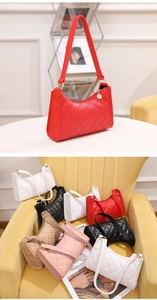 Close-up of quilted shoulder bag detailing with metal pendant and zipper closure