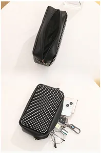 Vue détaillée du rangement intérieur du sac en similicuir noir avec rivets blancs
