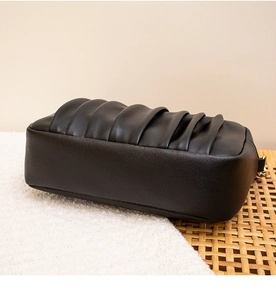 Détail de la texture plissée accordéon sur un sac à bandoulière en similicuir noir