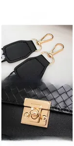 Close-up of black woven leather handbag with gold metal lock and carabiner hook details