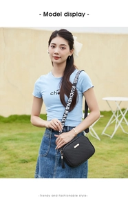 Detail of black embossed camera bag featuring a trendy wide strap worn by a model