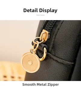 Détail de la fermeture éclair circulaire en métal doré sur le sac en cuir noir