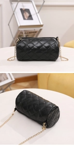Close-up of black quilted cylinder bag with gold chain strap and smooth zipper detail