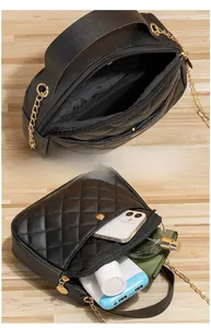 Detail of black quilted crossbody bag showing interior space with phone and accessories