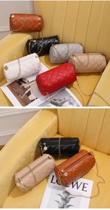 Multiple colorful quilted cylindrical chain bags displayed on a yellow velvet sofa