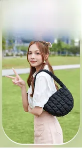 Nahaufnahme der schwarzen gesteppten Schultertasche mit geraffter Textur und Nähten