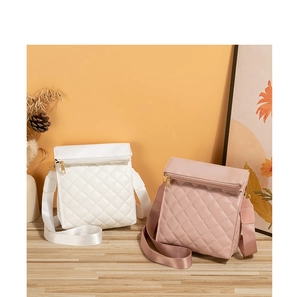 Detail of quilted diamond pattern crossbody bags in white and pink with wide strap