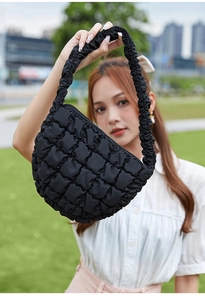 Detail der schwarzen gesteppten Puffer-Achseltasche mit 3D-Struktur und Raff-Schultergurt