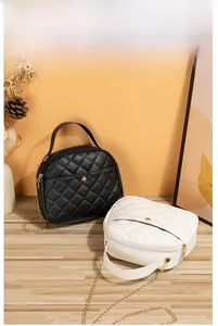 Close-up of black and white quilted shell crossbody bags with gold chain straps