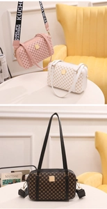 Detailed close-up of textured leather boston bags with wide fabric straps and metal plaques
