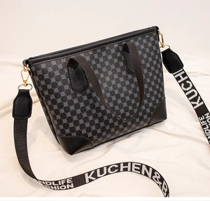 Detail of printed vintage tote bag with wide logo strap and leather reinforced corners