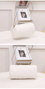 Detailed view of white quilted cylinder bag with gold chain strap and zipper close-up