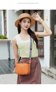 Close-up of orange crossbody bag featuring woven texture and tassel accessory