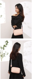 Gros plan d'un sac bandoulière rose avec rivets et sangle mode sur fond mural blanc