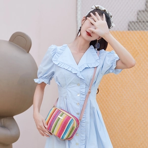 Colorful striped woven camera bag with rainbow straw patterns and pink leather strap
