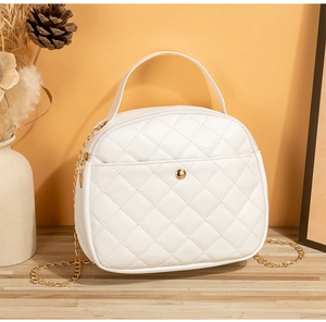 Detail of white quilted half-moon bag featuring gold chain strap and metal button buckle