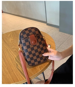 Detailed view of plaid crossbody bag featuring retro letter prints and golden metal hooks