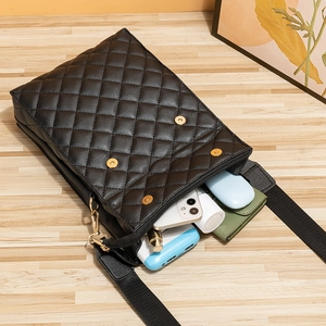 Black quilted crossbody bag with diamond pattern showing daily essentials inside