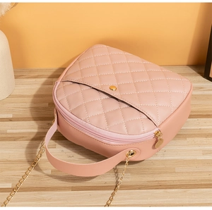 Detail showing pink quilted leather texture with gold buckle and chain on small crossbody bag