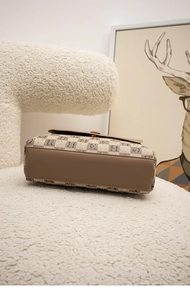 Detail of vintage brown checkerboard shoulder bag with smooth leather base and H-pattern