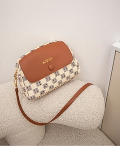 Detailed side view of the retro beige plaid shell bag with brown leather flap and strap