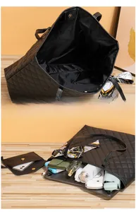 Détail du sac cabas matelassé noir montrant la grande capacité intérieure et la pochette