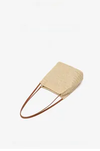 Gros plan du sac seau tissé beige avec texture à chevrons et fines anses marron foncé